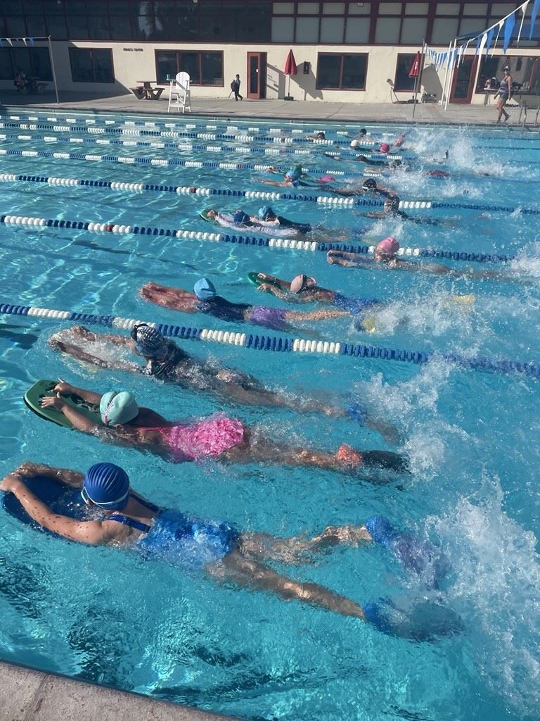 Campbell Recreation Summer Preview 2025 Cover, several swimmers using a kickboard in the pool.