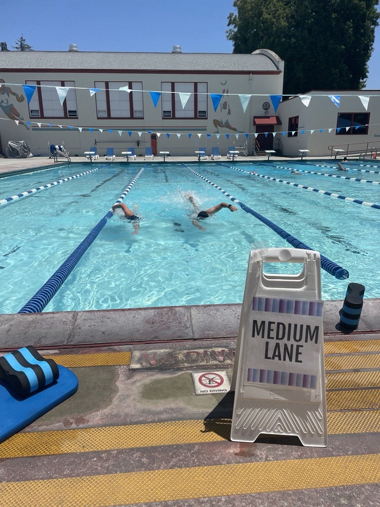 pool with two swimmers doing freestyle with a sign that says medium lane